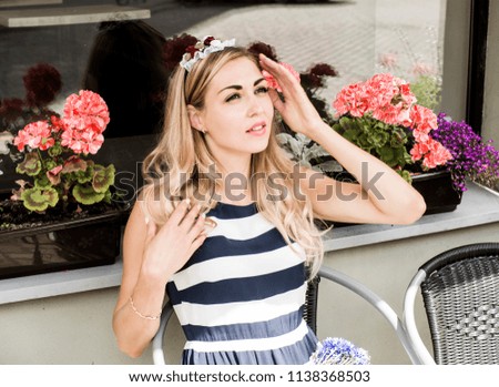 The beautiful woman hides from the sun in summer cafe