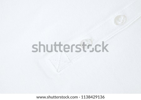 
White button sewn on a woolen fabric shot close-up