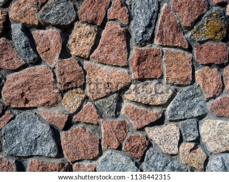 Fragment of a wall of colored granite stone