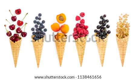 Set of assorted berries and fruit in waffle ice cream cone isolated on white background. Concept of healthy eating.