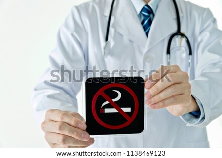 Doctor holding no smoking sign against white background.