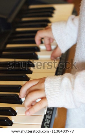 The hands of a little girl-pianist on the  synthesizer keys