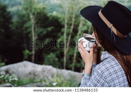 girl is drinking coffee in outdoor . Enjoying Nature on top of mountain concept adventure active vacations outdoor hiking sport