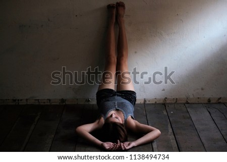 Portrait of young woman lying on wooden background that sadness and lonely in dark tone 