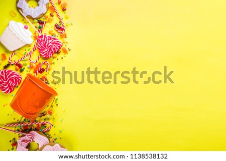 Halloween sweets concept, bucket in the form of a festive pumpkin, full of sweets and candies, cookies, jellies, desserts, bright yellow background top view copy space