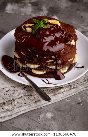 Chocolate pancakes with banana and chocolate sauce