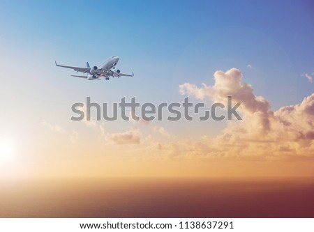 airplane flying above  ocean with sunset sky background   - travel concept