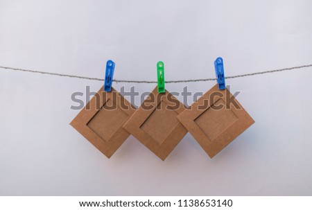 Colorful clothespins. note paper insert photo. over white background.
  on the rope attach the picture