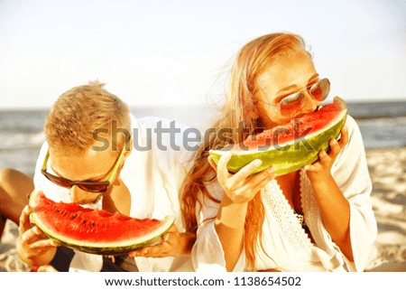 Summer time and two lovers with watermelon on beach. 