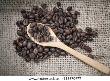  coffee beans with spoon over burlap sack background