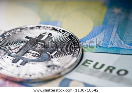 Bitcoin, close-up. Cryptocurrency. Euro banknotes background