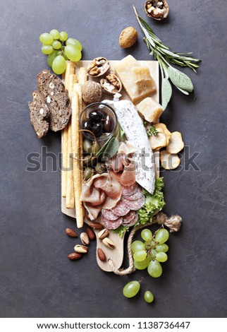 Mediterranean appetizers. Platter with tapas selection: jamon, cheese, olives and nuts.   Overhead view, copy space.