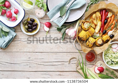 Food grilled vegetables outdoor table family dinner potato wedges roasted corn party picnic. Overhead view, copy space