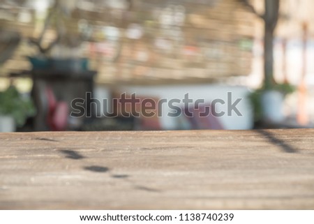 WOODEN TABLE AND SUN LIGHT BACKGROUND IN TRADITIONAL RESTAURANT 