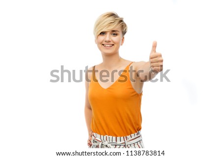 fashion, style and gesture concept - happy smiling young woman over white background showing thumbs up