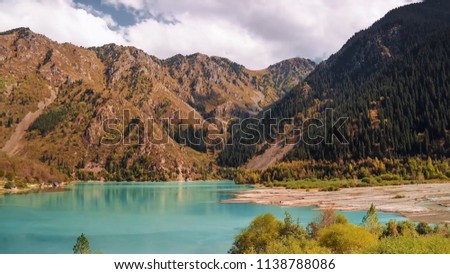 Idyllic summer landscape with clear mountain lake. Stock. Mountain lake landscape. View of the Sunny mountain valley with lakes and rivers