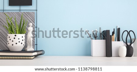 Home office desk with copy space on blue wall. Stylish workspace mock up.
