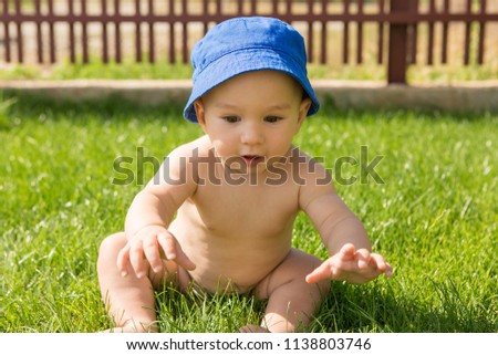 An infant is playing on the lawn
