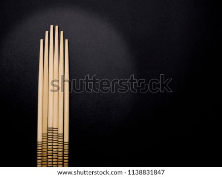 Wooden Chopsticks arranged on a black background.