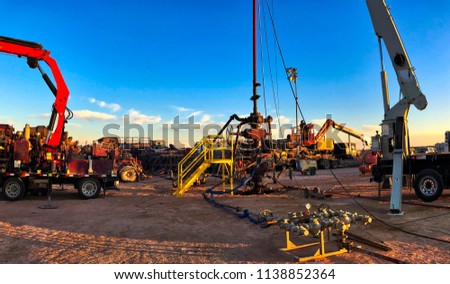 Fracking, well head connected to fracking pumps. Royalty-Free Stock Photo #1138852364