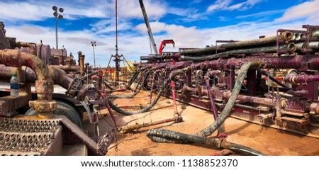 Fracking, well head connected to fracking pumps. Royalty-Free Stock Photo #1138852370