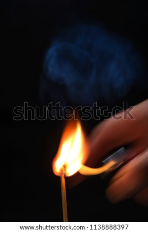 Burnt match in smoke on a black background