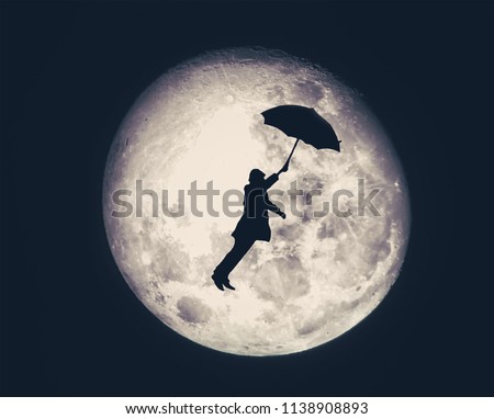 silhouette of a man flying on umbrella with full moon on a background