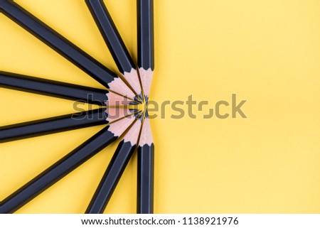 Black pencils over yellow background forming a semi circle Royalty-Free Stock Photo #1138921976