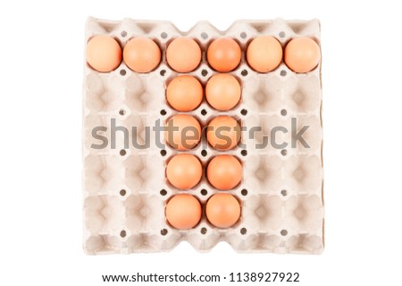 Top View of Raw brown Chicken Eggs In paper container tray box arranged English alphabet is " T " isolated on white background with clipping path.