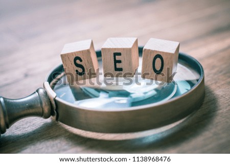 Vintage Magnifier With SEO Blocks On An Old Wooden Table - Search Engine Optimization Concept
