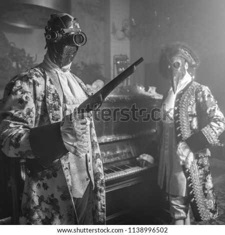 Actors in steam punk masks and antique costumes black-white art photo.