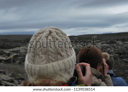Three heads of women taking photos of landscape in Iceland.