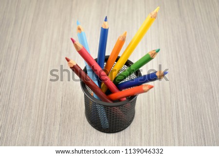 Color pencils stock images. Colored pencils in cup. Crayons on a wooden background. Set of colored pencils. Art supplies images. School supplies for drawing