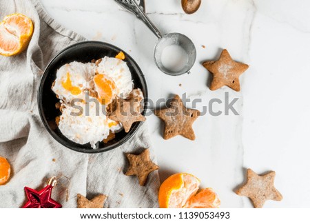 Winter Ice cream with gingerbread and tangerines, on white marble background, copy space top view