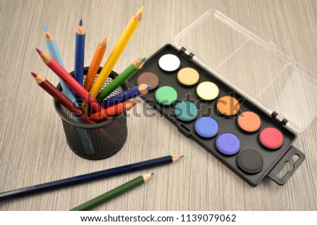 Watercolor tool stock images. Back to school border. Art supplies on a wooden background. School supplies for painting