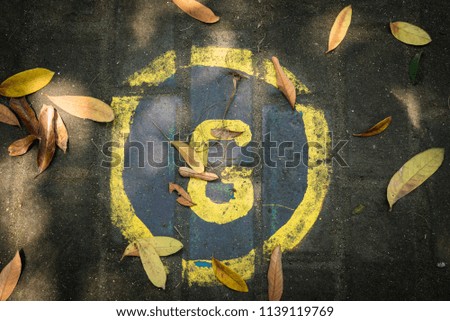 Street art of letter G surrounded by falling leaves