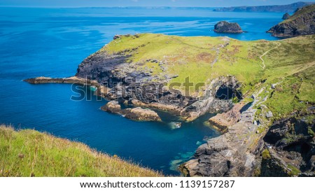 Merlin's Cave, green rocky cliffs, dramatic landscape with Atlantic Ocean / Celtic Sea view from Tintagel castle island in Cornwall, United Kingdom, UK. Western England coastline summer holidays. Royalty-Free Stock Photo #1139157287