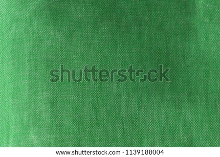 the textured background or wallpaper from rough fabric of green lime color and a blank space