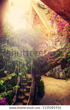 Artistic picture of an enchanted Asian style cottage in the woods and flowers.