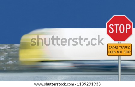Red stop road sign, motion blurred truck vehicle traffic background. Give way regulatory warning octagon white frame. Yellow cross traffic does not stop text signage metallic pole post blue summer sky
