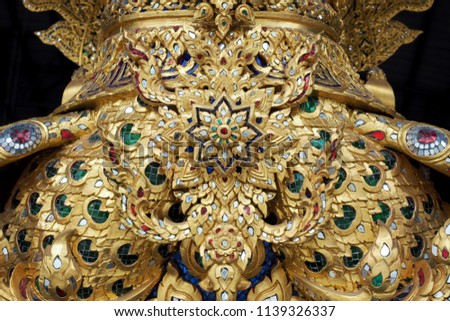 Elegant wood carving with ancient flower patterns decorating with gold and colorful mirrors, Thailand