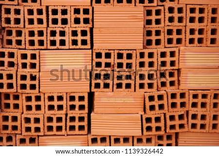 Stack of fired red clay bricks abstract horizontal background