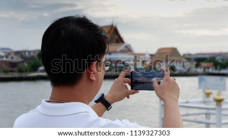 man taking pictures from mobile the nature background