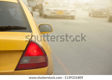 Yellow car break on the road by traffic jam on rush hour. Show red light for break.