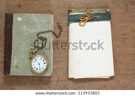 Old notepad, antique book, pocket watch, on wooden background