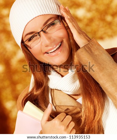 Picture of cute cheerful student girl in university autumn park, portrait of happy smiling teenager wearing stylish glasses, pretty smart pupil, back to school, education and knowledge concept