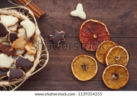 Top  view  of Christmas background. Christmas cookies and dry oranges on a brown wooden table.