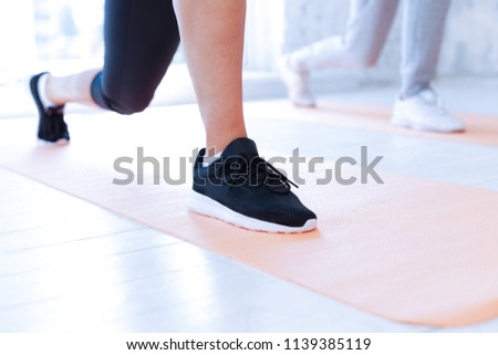 My equipment. Healthy sportswoman doing exercise and standing on the mat