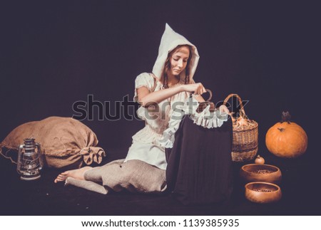 girl in a Halloween costume, with pumpkins, a bag of hay and rats on a black background