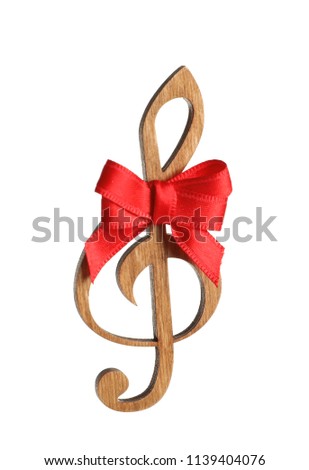 Wooden treble clef with bow on white background. Christmas music concept